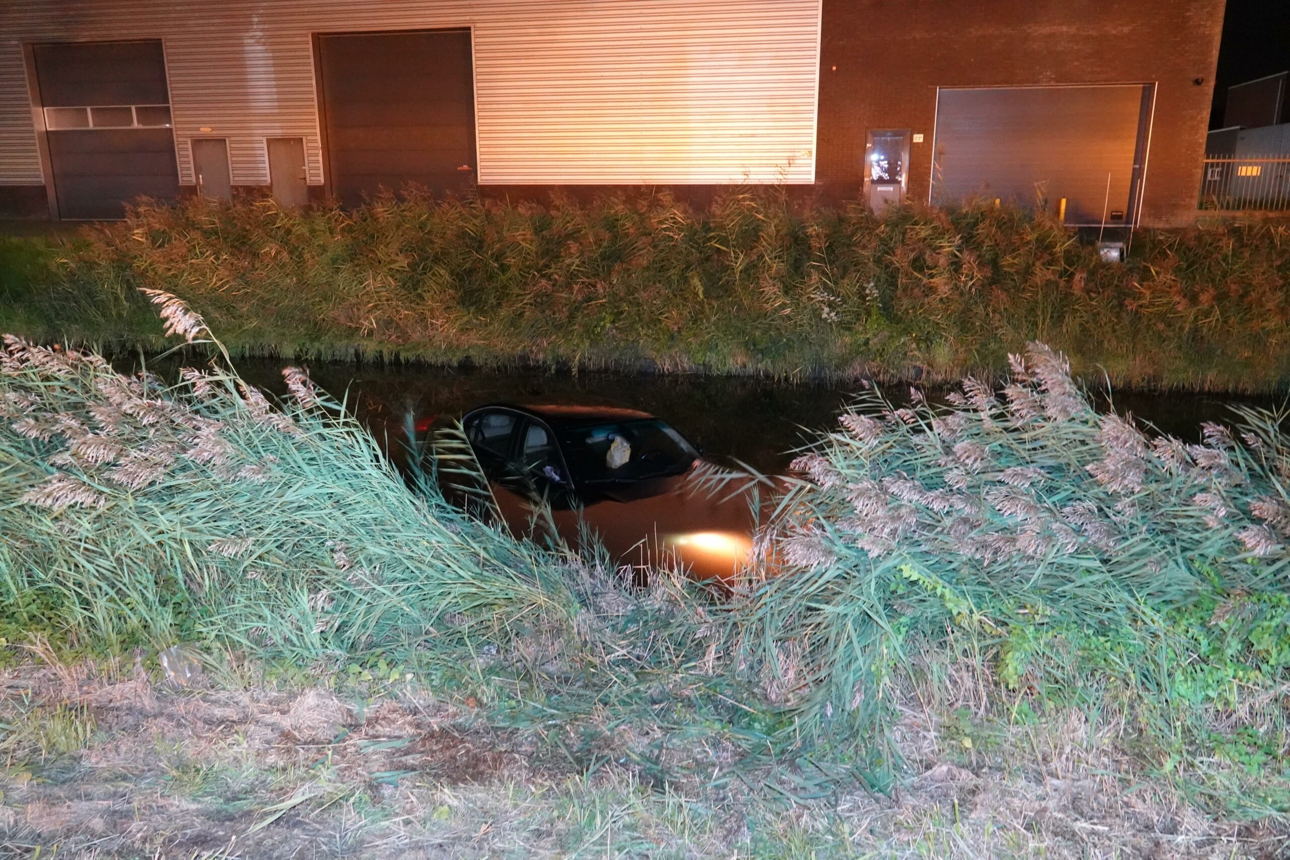 Auto te water langs De Corantijn in Zwaag